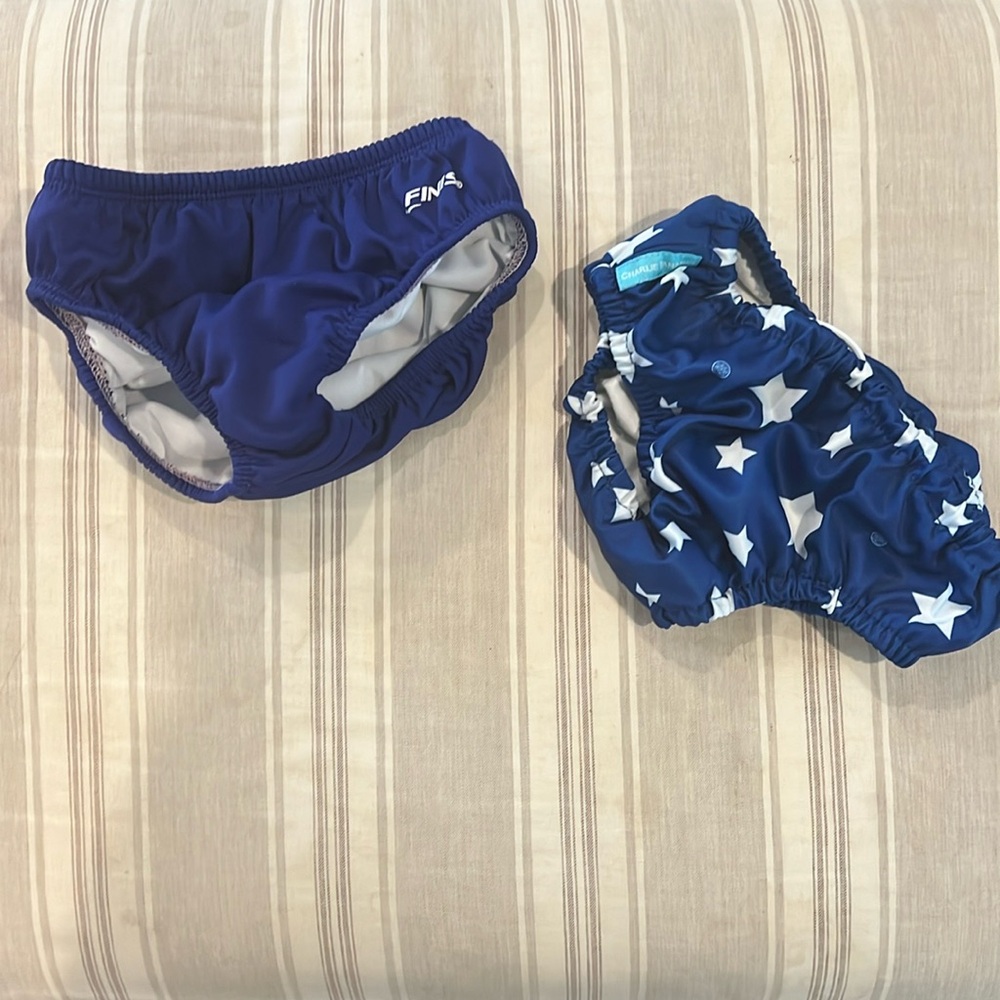Two reusable swim diaper covers, one from Finis and one from Charlie banana